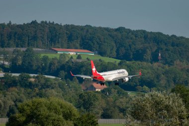 Zürih, İsviçre, 6 Eylül 2023 HB-JVM Helvetic Airways Embraer E190LR uçağı 14 numaralı piste iniyor.