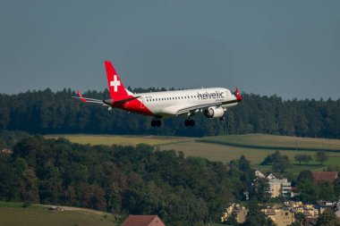 Zürih, İsviçre, 6 Eylül 2023 HB-JVM Helvetic Airways Embraer E190LR uçağı 14 numaralı piste iniyor.