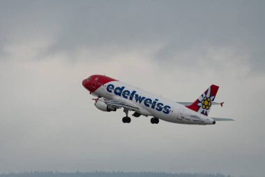 Zürih, İsviçre, 6 Aralık 2023 HB-JJN Edelweiss Air Airbus A320-214 uçağı kalkıyor.
