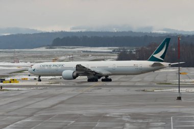 Zürih, İsviçre, 6 Aralık 2023 B-KPI Cathay Pasifik Boeing 777-367ER uçağı konumuna doğru ilerliyor.