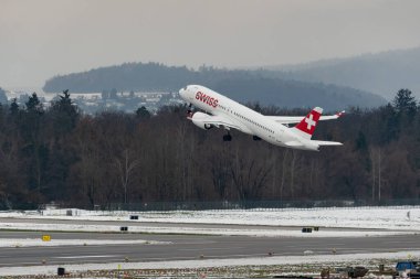 Zürih, İsviçre, 6 Aralık 2023 HB-JCT İsviçreli uluslararası havayolu Bombacısı CS-300 veya Airbus A220 uçağı kış mevsiminde 28. pistten kalkıyor.