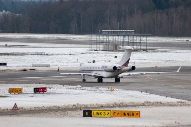 Zürih, İsviçre, 6 Aralık 2023 CS-GLD Bombardier Global 6000 uçağı kış mevsiminde park yerine doğru ilerliyor.