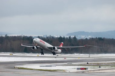 Zürih, İsviçre, 6 Aralık 2023 HB-JHG İsviçreli uluslararası havayolları Airbus A330-343 uçağı kış mevsiminde 16 numaralı pistten kalkıyor.