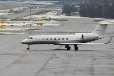Zürih, İsviçre, 6 Aralık 2023 EJ-KGRP Gulfstream G550 uçakları kış mevsiminde önlük üzerinde taksicilik yapıyor.