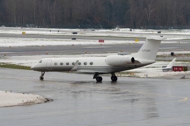 Zürih, İsviçre, 6 Aralık 2023 EJ-KGRP Gulfstream G550 uçakları kış mevsiminde önlük üzerinde taksicilik yapıyor.