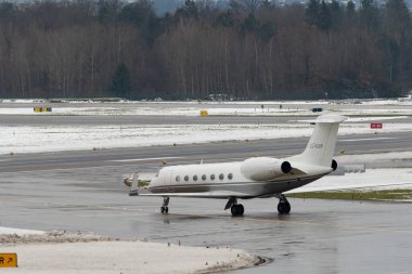 Zürih, İsviçre, 6 Aralık 2023 EJ-KGRP Gulfstream G550 uçakları kış mevsiminde önlük üzerinde taksicilik yapıyor.