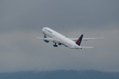 Zürih, İsviçre, 6 Aralık 2023 C-FIUL Air Canada Boeing 777-33ER uçağı kış mevsiminde 28. pistten kalkıyor.