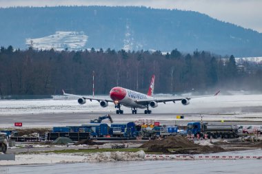 Zürih, İsviçre, 6 Aralık 2023 HB-JMF Edelweiss Air Airbus A340-313 sefer sayılı uçak kış mevsiminde 16. pistten havalanmıştır.