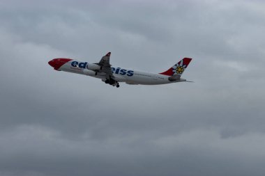 Zürih, İsviçre, 6 Aralık 2023 HB-JMF Edelweiss Air Airbus A340-313 sefer sayılı uçak kış mevsiminde 16. pistten havalanmıştır.