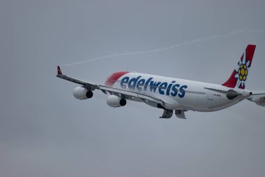 Zürih, İsviçre, 6 Aralık 2023 HB-JMF Edelweiss Air Airbus A340-313 sefer sayılı uçak kış mevsiminde 16. pistten havalanmıştır.