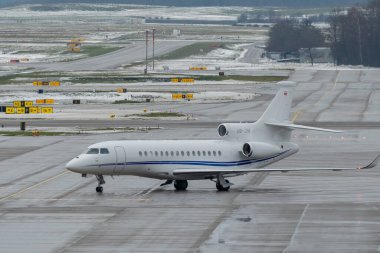 Zürih, İsviçre, 6 Aralık 2023 HB-JIM Dessault Falcon 8X uçakları önlüğe yanaşıyor.
