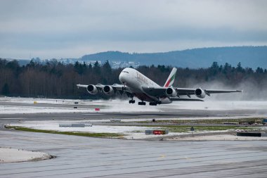 Zürih, İsviçre, 6 Aralık 2023 A6-EOC Emirlikleri Airbus A380-861 uçağı kış mevsiminde 16 numaralı pistten kalkıyor.