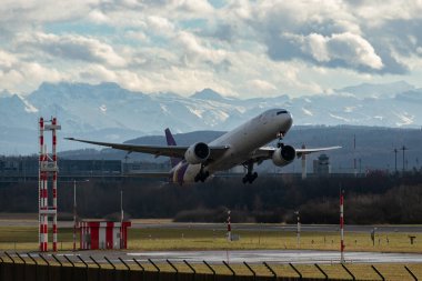 Zürih, İsviçre, 4 Ocak 2024 HS-TKR Tayland Havayolları Boeing 777-3ALER uçağı 32 numaralı pistten kalkıyor.