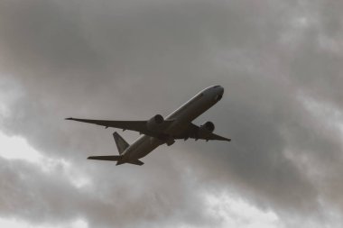 Zürih, İsviçre, 4 Ocak 2024 9V-SWV Singapur Havayolları Boeing 777-312ER uçağı 32 nolu pistten yağmur yağmuru sırasında kalkıyor.