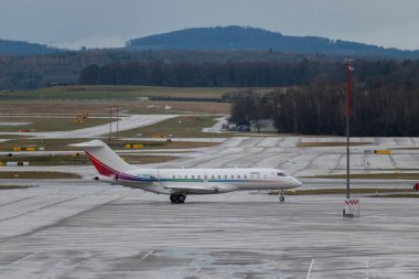 Zürih, İsviçre, 18 Ocak 2024 VT-AGL Bombardier Global 6500 uçakları Davos 'taki dünya ekonomik forumu sırasında yağmur altında taksicilik yapıyor.