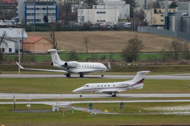 Zürih, İsviçre, 17 Ocak 2024 CS-PHO Ağ Jetleri Avrupa Embraer Fenomen 300 uçakları, Davos 'taki dünya ekonomik forumu sırasında yağmurlu bir günde taksicilik yapıyor.