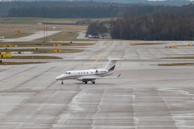 Zürih, İsviçre, 17 Ocak 2024 CS-PHO Ağ Jetleri Avrupa Embraer Fenomen 300 uçakları, Davos 'taki dünya ekonomik forumu sırasında yağmurlu bir günde taksicilik yapıyor.