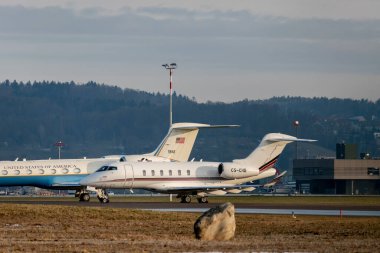 Zürih, İsviçre, 16 Ocak 2024 CS-CHB Net Jets Europe Bombacı Challenger 350 uçağı Davos 'taki dünya ekonomik forumu sırasında ABD Hava Kuvvetleri Körfezi C-37B uçağının önüne park ediyor.