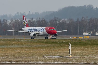 Zürih, İsviçre, 14 Ocak 2024 HB-IJV Edelweiss Air Airbus A320-214 uçağı kalkıyor.