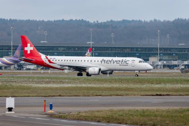 Zürih, İsviçre, 15 Ocak 2024 HB-JVN Helvetic Airways Embraer E190LR uçağı konumuna doğru ilerliyor.