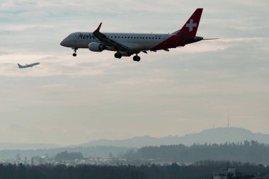 Zürih, İsviçre, 16 Ocak 2024 HB-JVO Helvetic Airways Embraer E190-LR uçağı 14. piste yaklaşmaktadır.