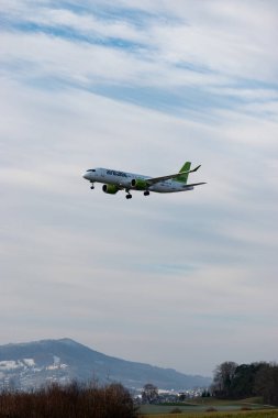 Zürih, İsviçre, 16 Ocak 2024 YL-AAAO Hava Baltık Bombacısı CS-300 veya Airbus A220-300 uçağı 14 numaralı piste yaklaşmaktadır.