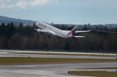 Zürih, İsviçre, 17 Ocak 2024 A7-HJJ Katar Havayolları Airbus A330-202 uçağı yağmurlu bir günde 28. pistten kalkıyor.