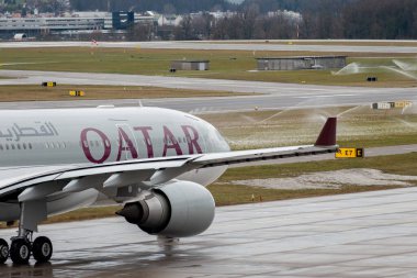 Zürih, İsviçre, 17 Ocak 2024 A7-HJJ Katar Havayolları Airbus A330-202, yağmurlu bir günde kalkış konumuna geçiyor.