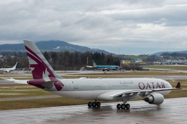 Zürih, İsviçre, 17 Ocak 2024 A7-HJJ Katar Havayolları Airbus A330-202, yağmurlu bir günde kalkış konumuna geçiyor.