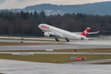 Zürih, İsviçre, 17 Ocak 2024 HB-JHB İsviçreli uluslararası havayolları Airbus A330-343 uçağı yağmurlu bir günde 28 numaralı pistten kalkıyor.