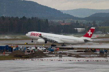Zürih, İsviçre, 17 Ocak 2024 HB-JHB İsviçreli uluslararası havayolları Airbus A330-343 uçağı yağmurlu bir günde 28 numaralı pistten kalkıyor.