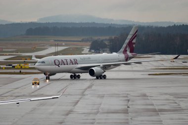 Zürih, İsviçre, 17 Ocak 2024 A7-HJJ Katar Havayolları Airbus A330-202 bir yağmur yağışı sırasında önlük boyunca hareket etmektedir.