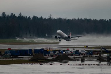 Zürih, İsviçre, 17 Ocak 2024 HB-JPD İsviçreli uluslararası havayolu Airbus A321-271 NX uçağı 16 nolu pistten bir yağmur yağışı sırasında kalkıyor.