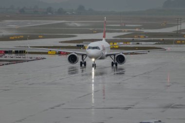 Zürih, İsviçre, 17 Ocak 2024 HB-JDA İsviçreli uluslararası havayolu Airbus A320-271N uçağı yağmurlu bir duş sırasında kapıya yanaşıyor.