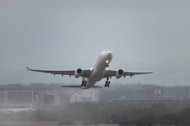 Zürih, İsviçre, 18 Ocak 2024 HB-JHE İsviçreli uluslararası havayolu Airbus A330-343 uçağı yağmurlu bir sağanak sırasında 32 numaralı pistten kalkıyor.