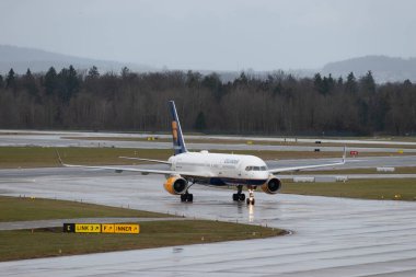 Zürih, İsviçre, 18 Ocak 2024 TF-FIK İzlanda Hava Yolları Boeing 757-256 bir yağmur yağışı sırasında kapıya doğru ilerliyor.