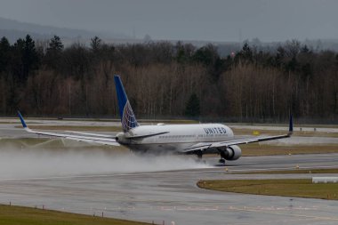 Zürih, İsviçre, 18 Ocak 2024 N-686UA Birleşik Havayolları Boeing 767-3CB-ER uçağı 34 numaralı pistten bir yağmur yağmuru sırasında kalkıyor.