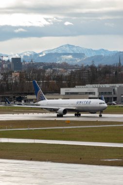 Zürih, İsviçre, 18 Ocak 2024 N-686UA Birleşik Havayolları Boeing 767-3CB-ER uçağı 34 numaralı pistten bir yağmur yağmuru sırasında kalkıyor.