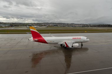 Zürih, İsviçre, 18 Ocak 2024 EC-MCS İberya Airbus A320-214 bir yağmur yağışı sırasında kalkış pozisyonuna geçiyor.