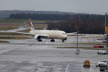 Zürih, İsviçre, 18 Ocak 2024 A6-BMF Etihad Havayolları Boeing 787-10 Dreamliner uçakları yağmur altında önlük boyunca ilerliyorlar.