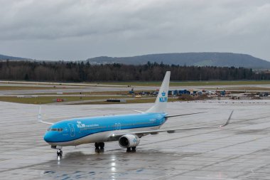 Zürih, İsviçre, 18 Ocak 2024 PH-BXS KLM Hollanda Kraliyet Hava Yolları Boeing 737-9K2 uçakları yağmur altında kapıya doğru ilerliyorlar.