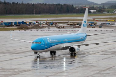 Zürih, İsviçre, 18 Ocak 2024 PH-BXS KLM Hollanda Kraliyet Hava Yolları Boeing 737-9K2 uçakları yağmur altında kapıya doğru ilerliyorlar.