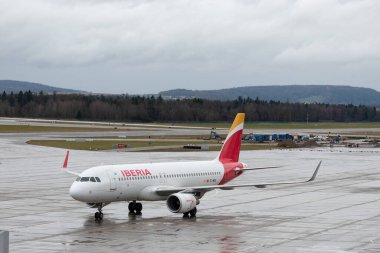 Zürih, İsviçre, 18 Ocak 2024 EC-MCS İberya Airbus A320-214 bir yağmur yağışı sırasında kapıya doğru ilerliyor.