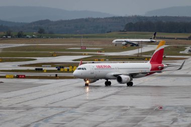 Zürih, İsviçre, 18 Ocak 2024 EC-MCS İberya Airbus A320-214 bir yağmur yağışı sırasında kapıya doğru ilerliyor.