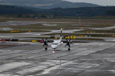 Zürih, İsviçre, 18 Ocak 2024 9A-CQC Hırvatistan Havayolları De Havilland Dash-8-400 pervaneli uçak yağmurlu bir duş sırasında kapıya yanaşıyor