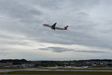Zurich, Switzerland, January 18, 2024 HB-JHN Swiss international airlines Airbus A330-343 aircraft is departing from runway 16 during a rain shower clipart
