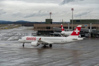 Zürih, İsviçre, 18 Ocak 2024 HB-JCL İsviçreli bombardıman uçağı CS-300 veya Airbus A220-300 uçakları bir yağmur yağışı sırasında önlük boyunca hareket ediyor