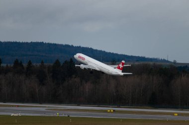 Zürih, İsviçre, 18 Ocak 2024 HB-IOF İsviçreli uluslararası havayolu Airbus A321-111 uçağı, 28 numaralı pistten yağmur yağışlı bir havada kalkıyor.