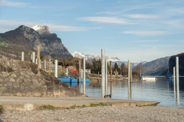 Weesen, Switzerland, March 22, 2024 Sunny day in spring time at the coast of the lake Walensee surrounded by the majestic swiss alps clipart