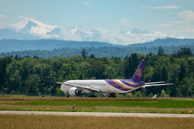 Zürih, İsviçre, 16 Haziran 2024 HS-TKP Tayland Havayolları Boeing 777-3ALER uçağı 16 numaralı piste yanaşıyor.
